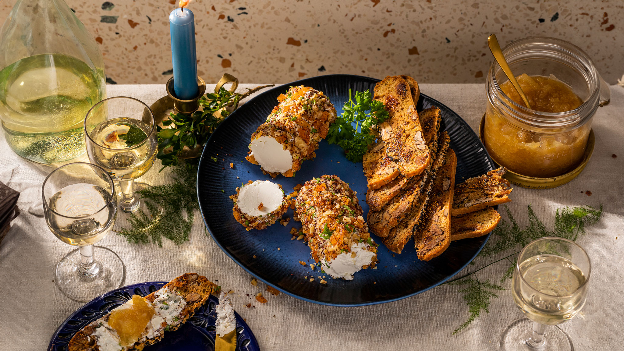 Verse geitenkaas met een kruidenkorstje, crackers en perencompote